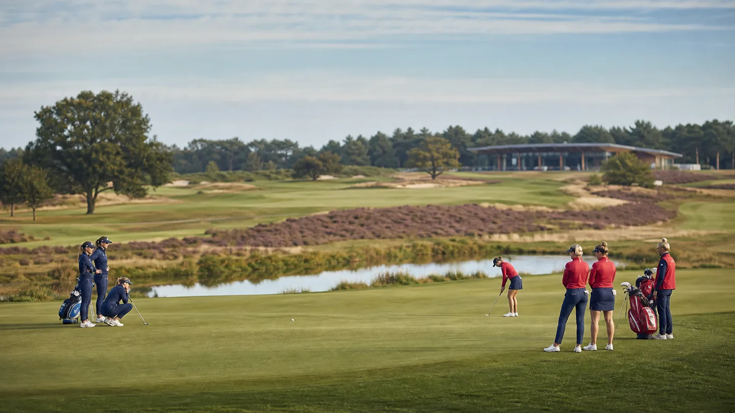 Två lag med kvinnliga golfare vid en green på en nederländsk hedlandsbana.